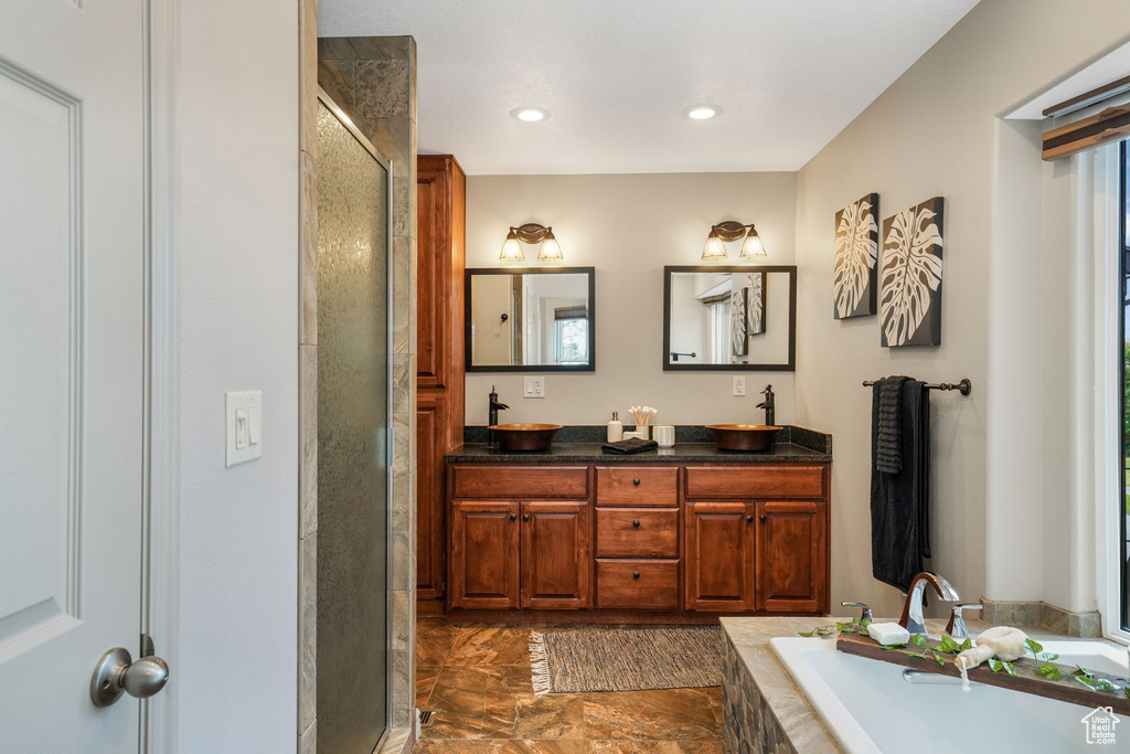 Bathroom featuring double vanity, a bath, a shower stall, and recessed lighting