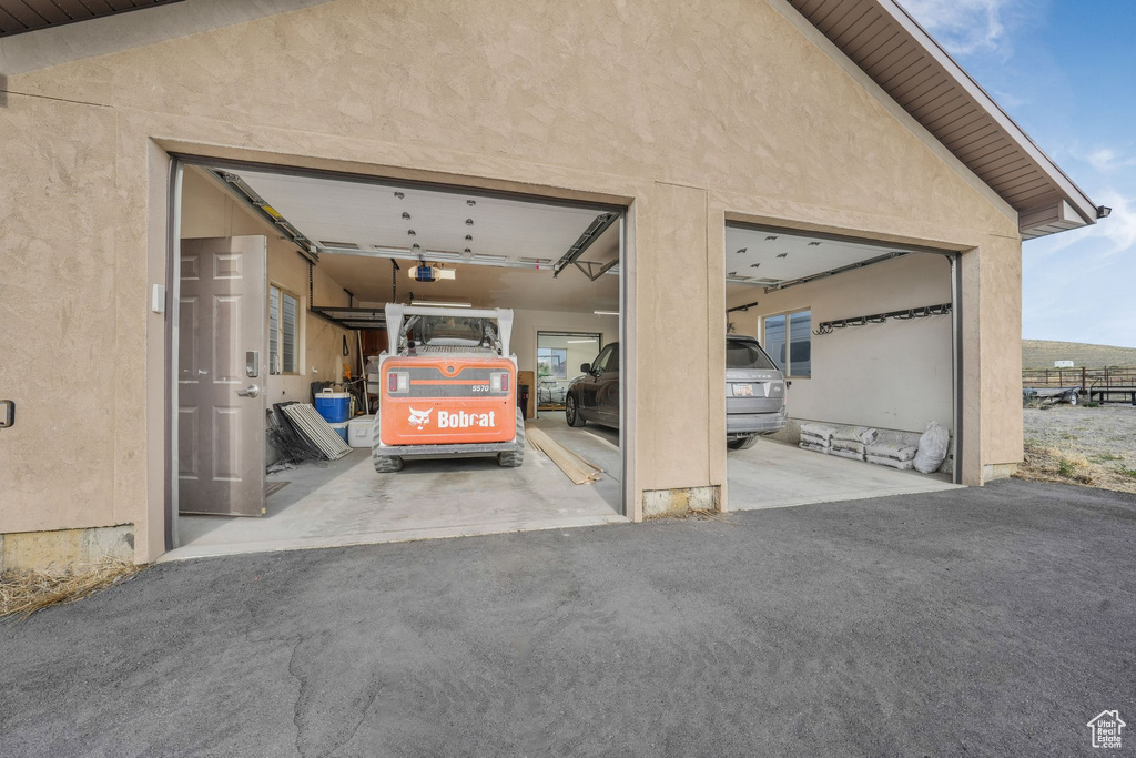 Garage with a garage door opener and asphalt driveway