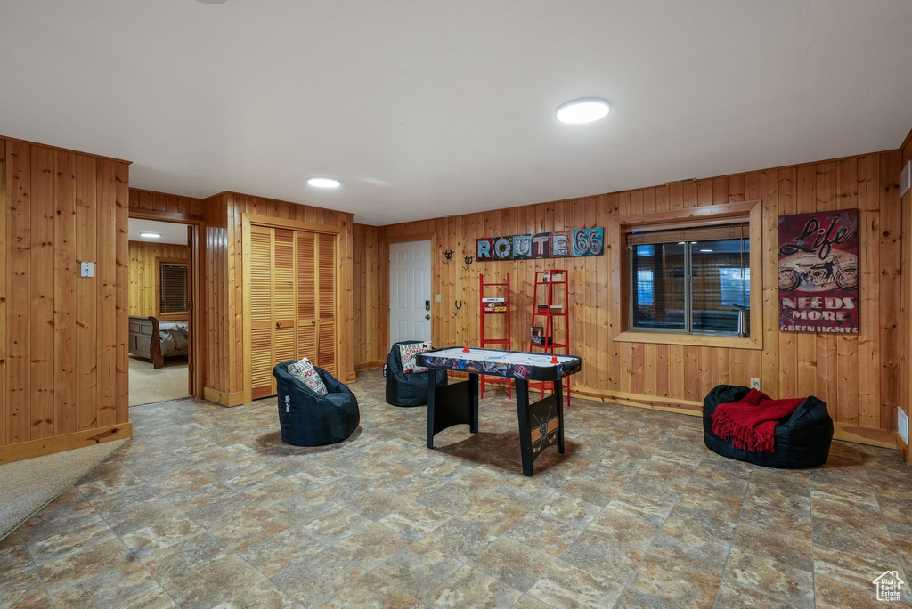 Playroom featuring wooden walls and stone finish flooring
