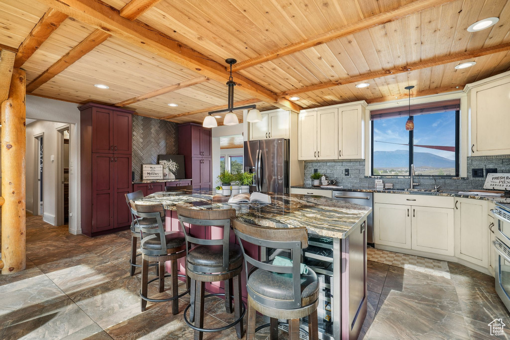Kitchen featuring stainless steel appliances, a wood ceiling with exposed beams, plenty of natural light, backsplash, and recessed lighting