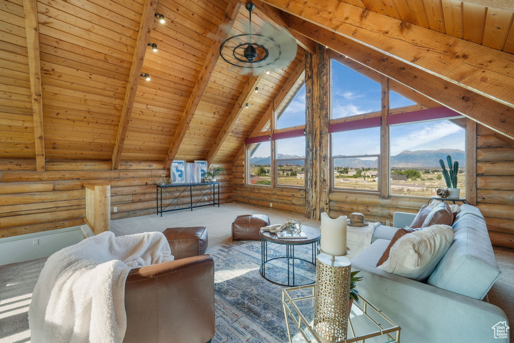 Living room featuring rustic walls, wood ceiling, carpet, and a mountain view