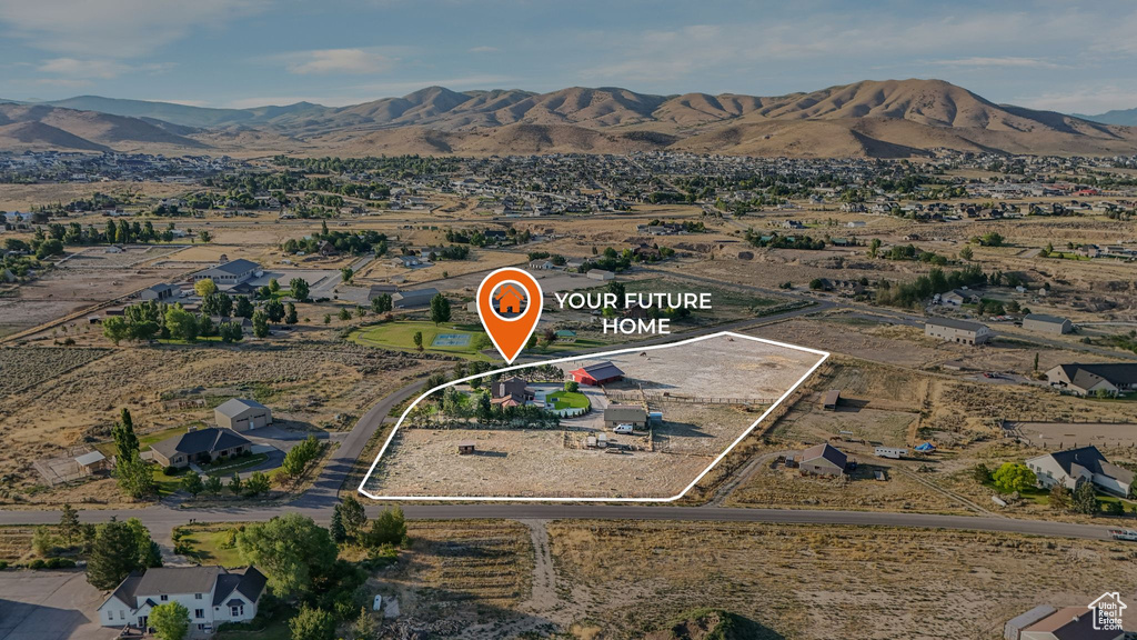 Aerial overview of property's location featuring a mountainous background and property boundaries highlighted