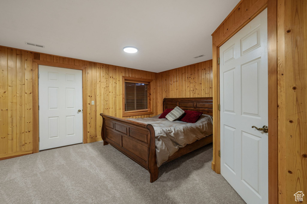 Bedroom featuring carpet and wood walls