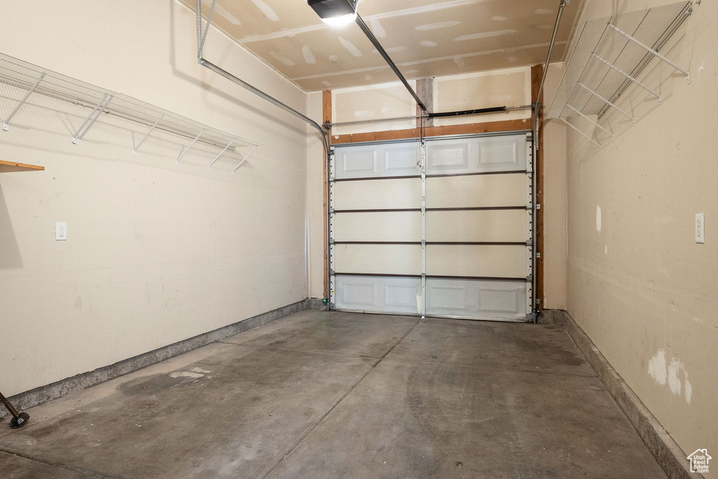 Garage with baseboards and a garage door opener