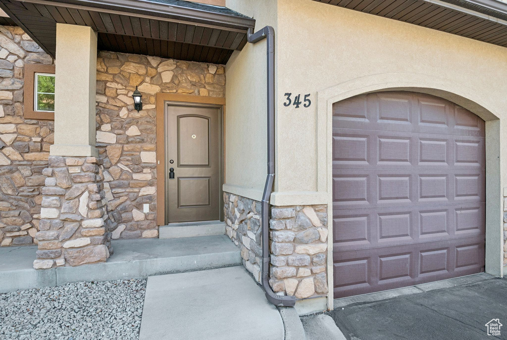 Entrance to property featuring stone siding and stucco siding