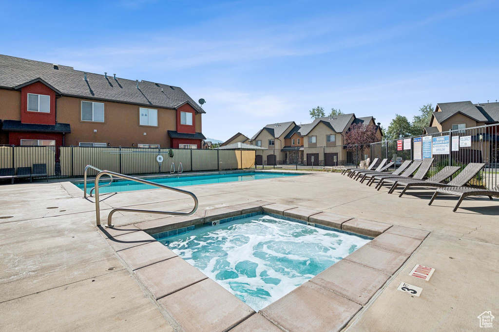 Community pool with a residential view, a community hot tub, and a patio
