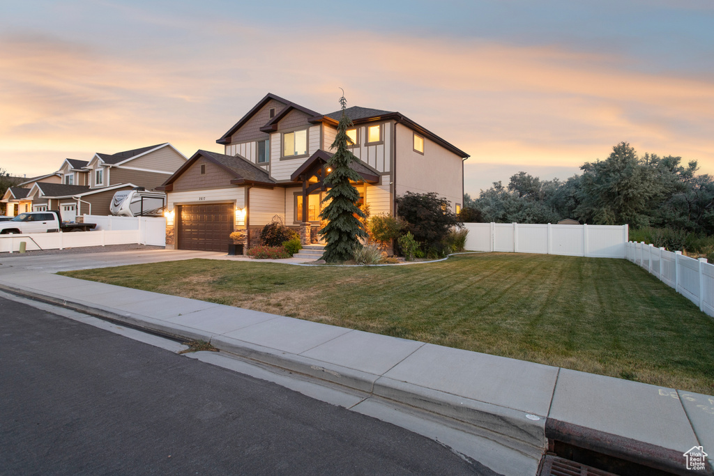 View of front facade with driveway, an attached garage, and stone siding