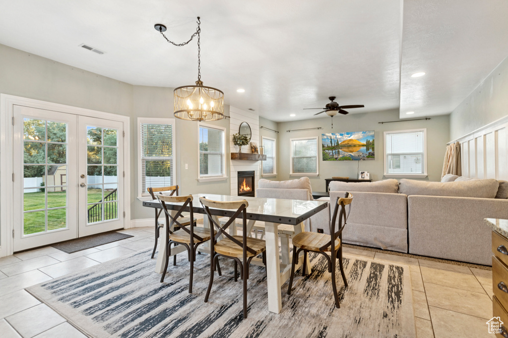 Dining space featuring light tile patterned floors, french doors, recessed lighting, a fireplace, and ceiling fan