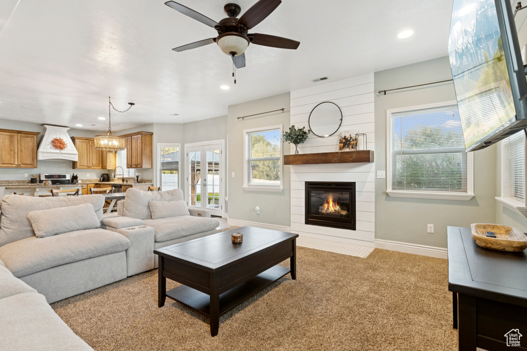 Living area featuring a ceiling fan, a fireplace, plenty of natural light, recessed lighting, and light colored carpet