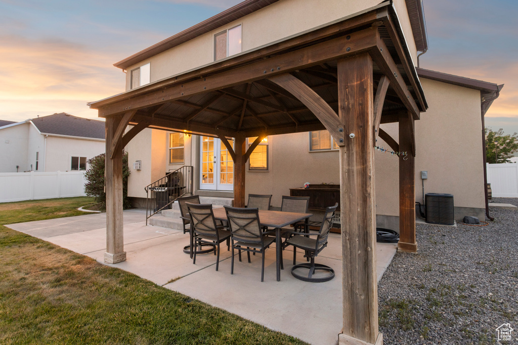 Patio terrace at dusk featuring a gazebo, a patio area, and french doors