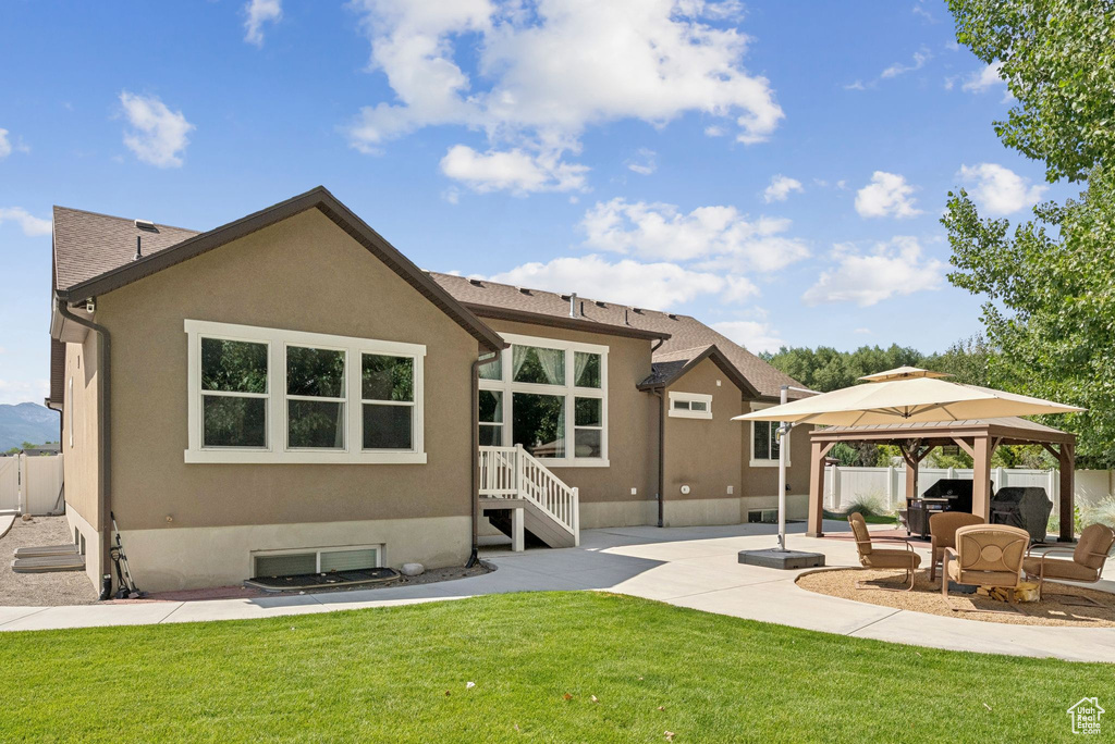 Back of house with a gazebo, a patio area, and stucco siding