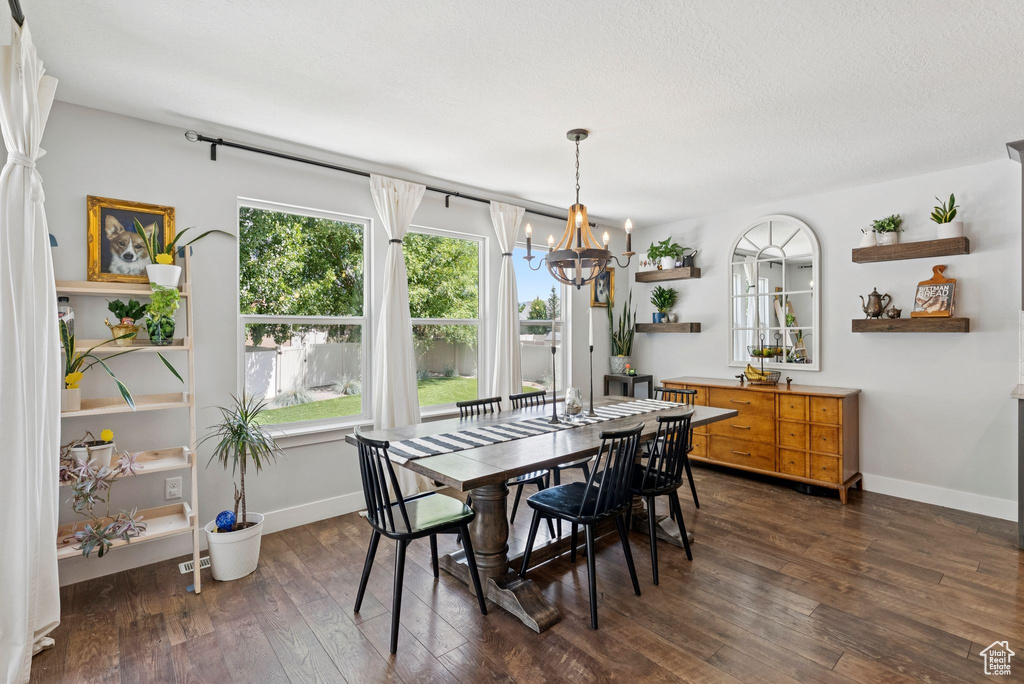 Dining area featuring a chandelier and dark wood finished floors