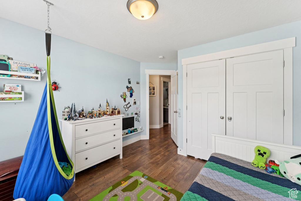 Bedroom with dark wood-type flooring and a closet