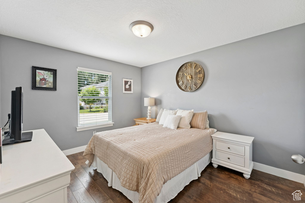 Bedroom featuring baseboards and dark wood-type flooring