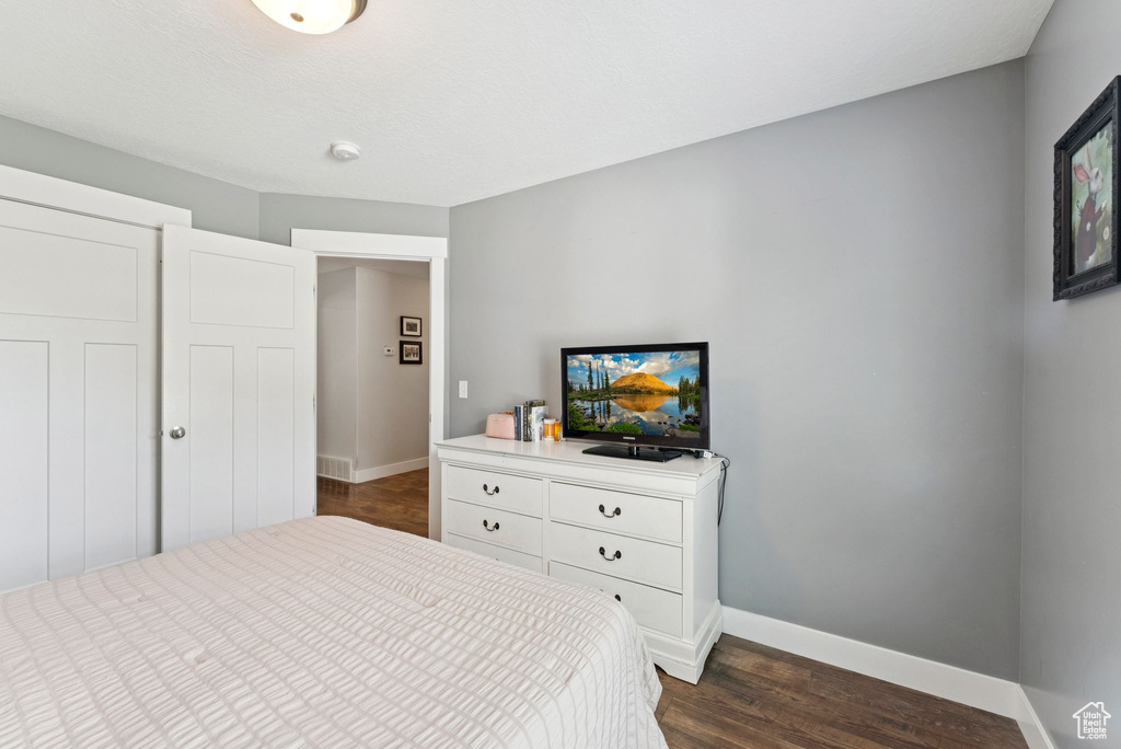 Bedroom featuring baseboards and dark wood-type flooring