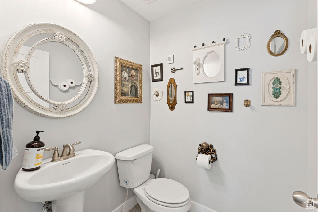 Half bath with a sink and baseboards