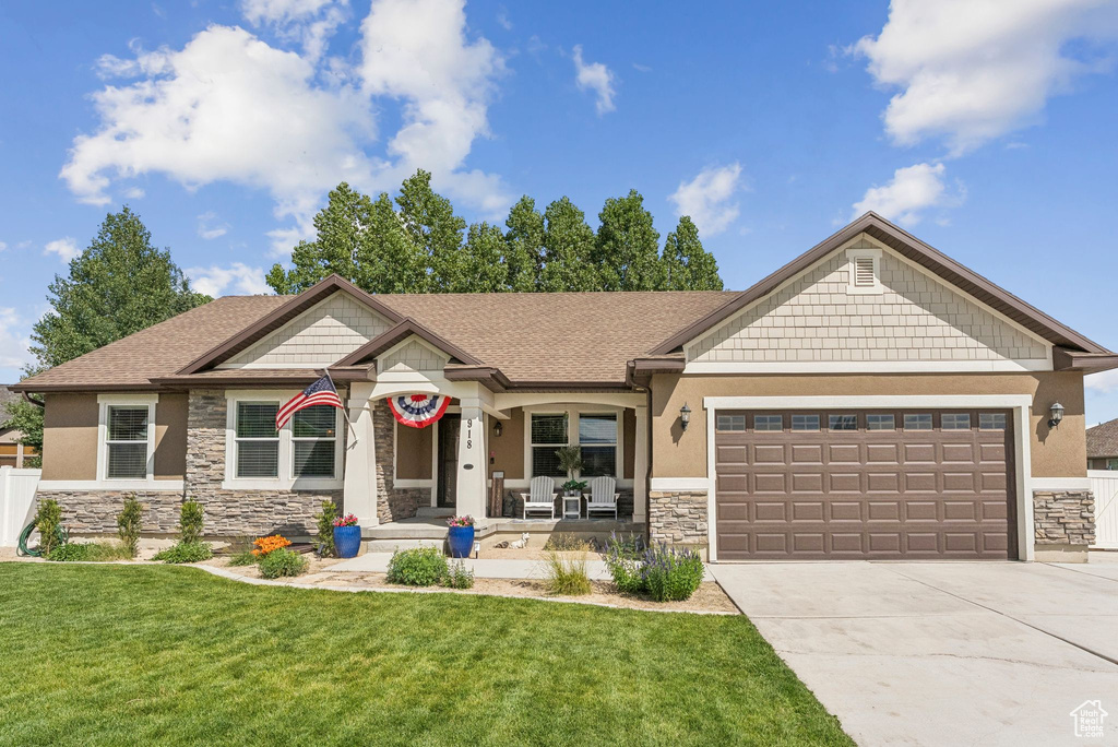Craftsman-style home with stone siding, concrete driveway, an attached garage, stucco siding, and a shingled roof