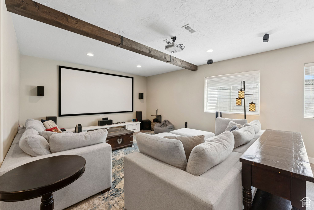 Home theater with healthy amount of natural light, beamed ceiling, and recessed lighting