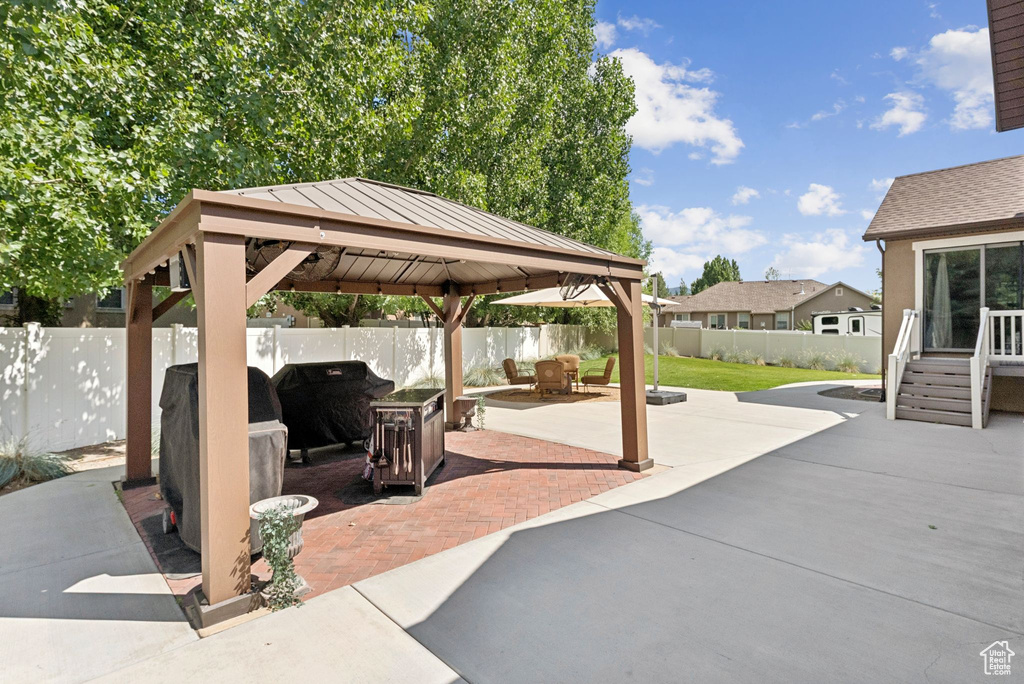 Fenced backyard with a gazebo, a patio area, and area for grilling