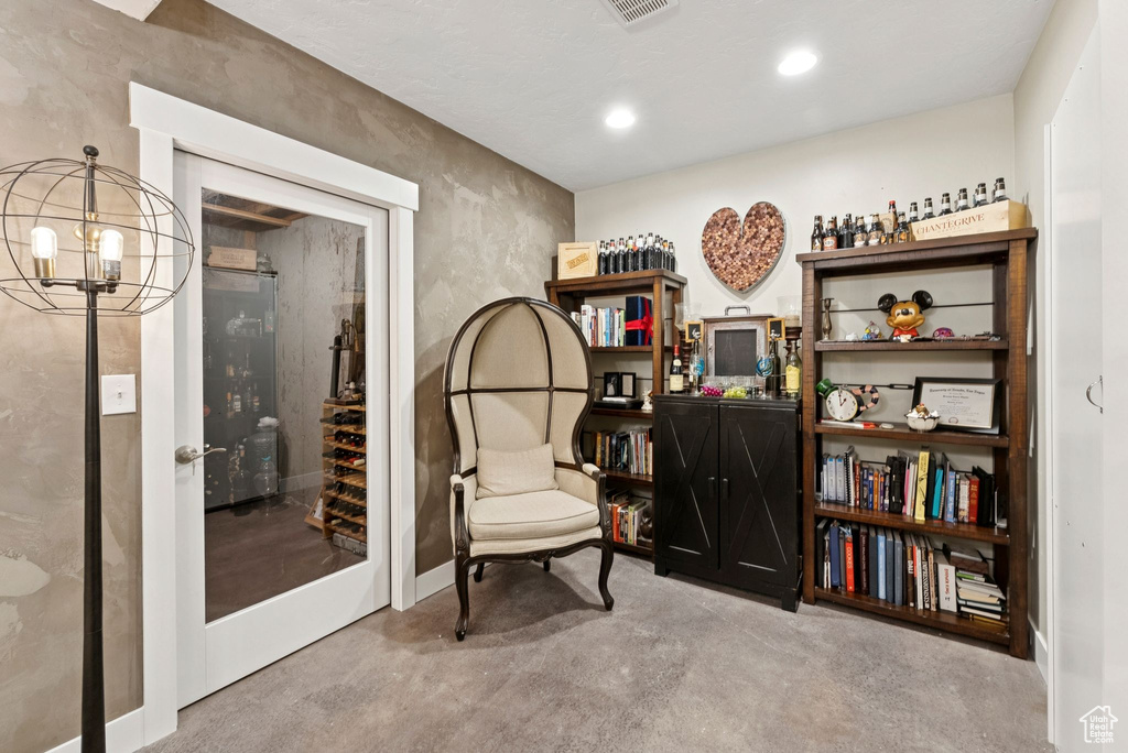 Living area featuring concrete floors, a chandelier, and recessed lighting