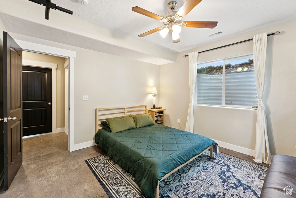 Bedroom featuring concrete floors and a ceiling fan