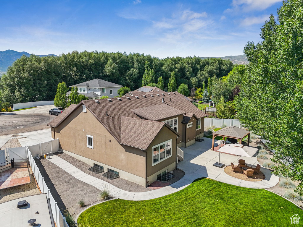 Aerial view of property and surrounding area featuring a mountain backdrop