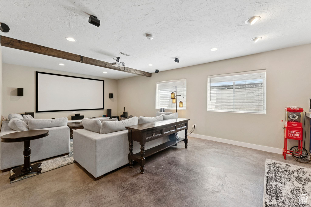 Home theater with finished concrete floors, a textured ceiling, and recessed lighting