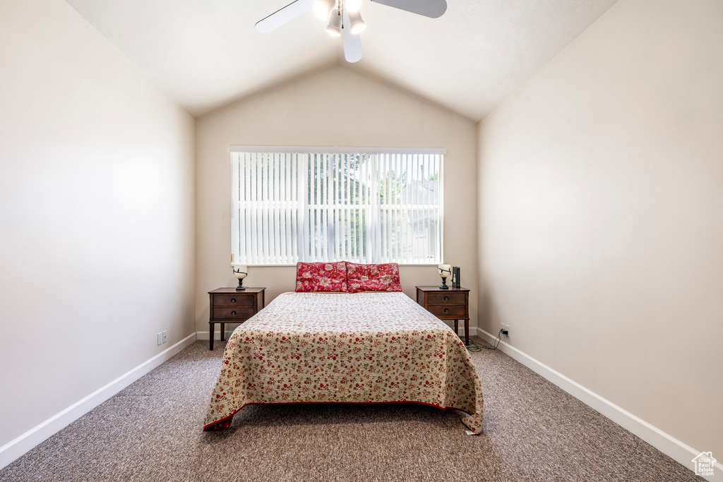 Bedroom featuring light carpet, lofted ceiling, and a ceiling fan