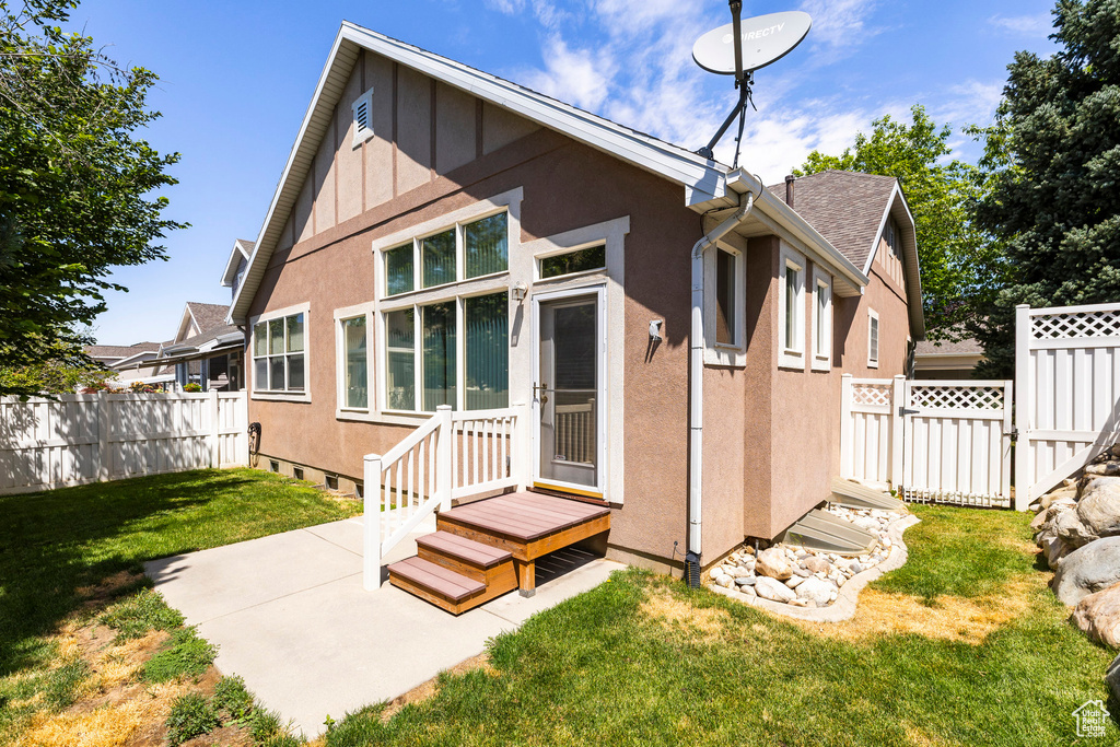 Rear view of house with stucco siding and a patio area