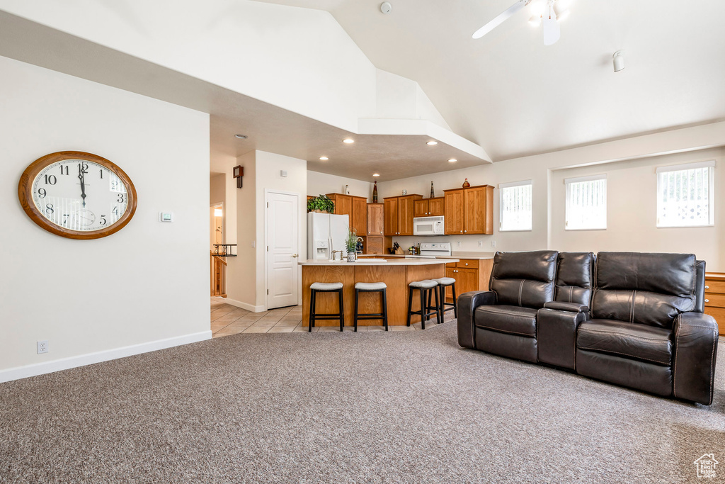 Living area with light carpet, healthy amount of natural light, high vaulted ceiling, recessed lighting, and a ceiling fan