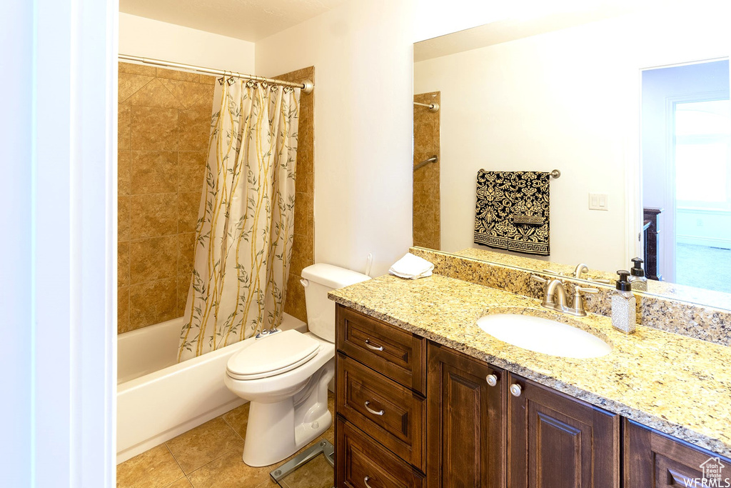 Bathroom featuring vanity, shower / bath combo, and tile patterned floors