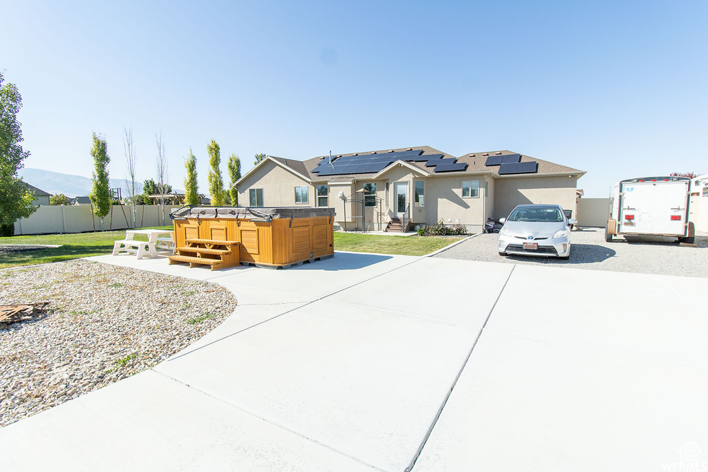 View of front facade featuring roof mounted solar panels and stucco siding