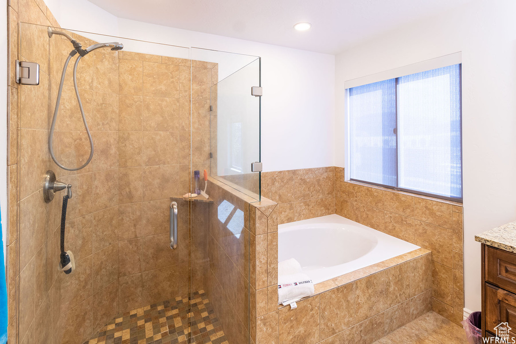 Full bath featuring a stall shower, a bath, and vanity