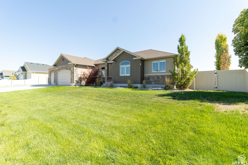 Ranch-style house with concrete driveway, stone siding, an attached garage, a gate, and roof with shingles