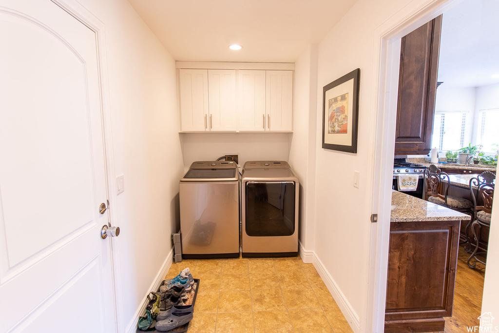 Laundry area with independent washer and dryer, cabinet space, and recessed lighting