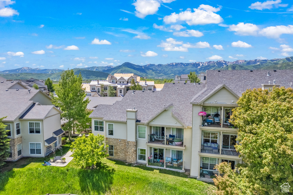 Rear view of property with a mountain view, a residential view, and roof with shingles