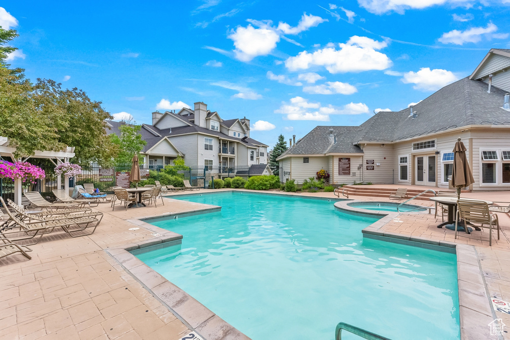 Community pool featuring a hot tub, french doors, a patio, and a residential view