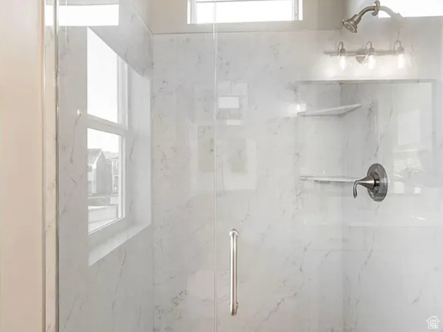 Full bath with a marble finish shower