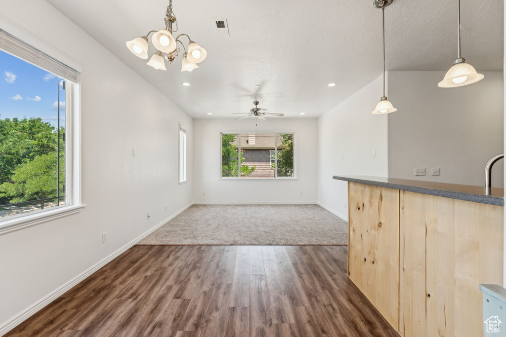 Unfurnished living room with a chandelier, dark wood-style floors, recessed lighting, and ceiling fan