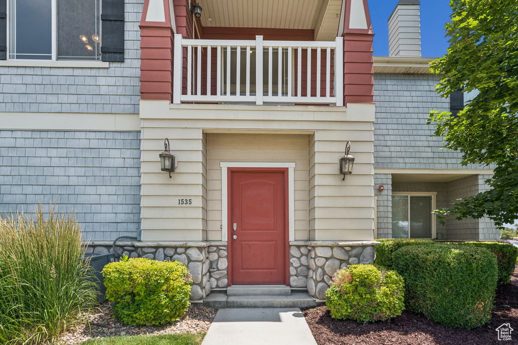 Entrance to property featuring a balcony and stone siding