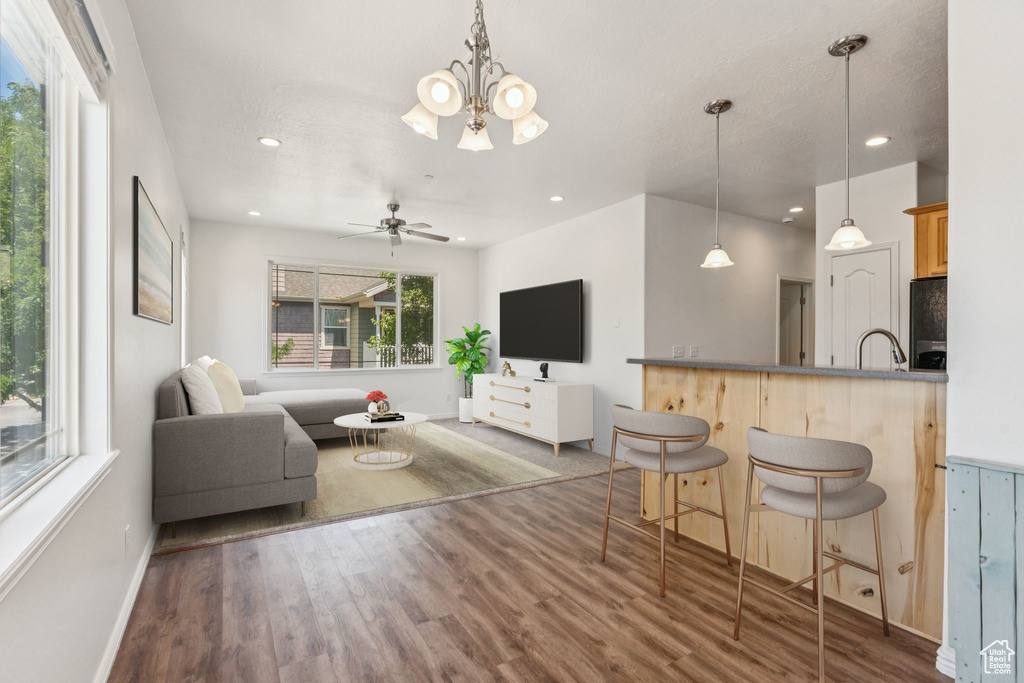 Living area featuring wood finished floors, a chandelier, recessed lighting, and ceiling fan