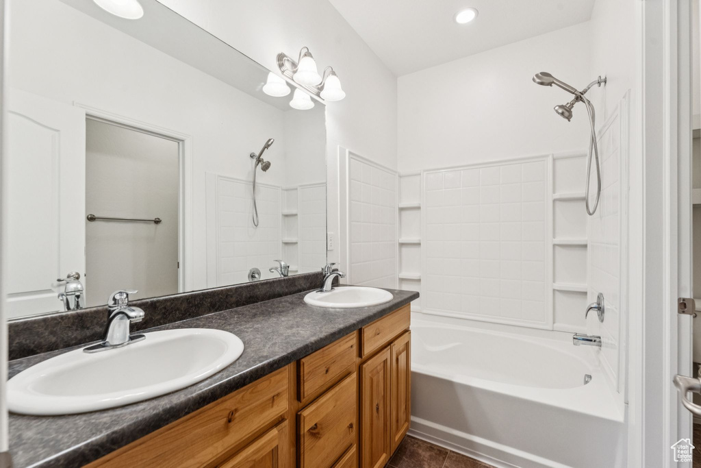 Full bath with  shower combination, double vanity, and tile patterned floors