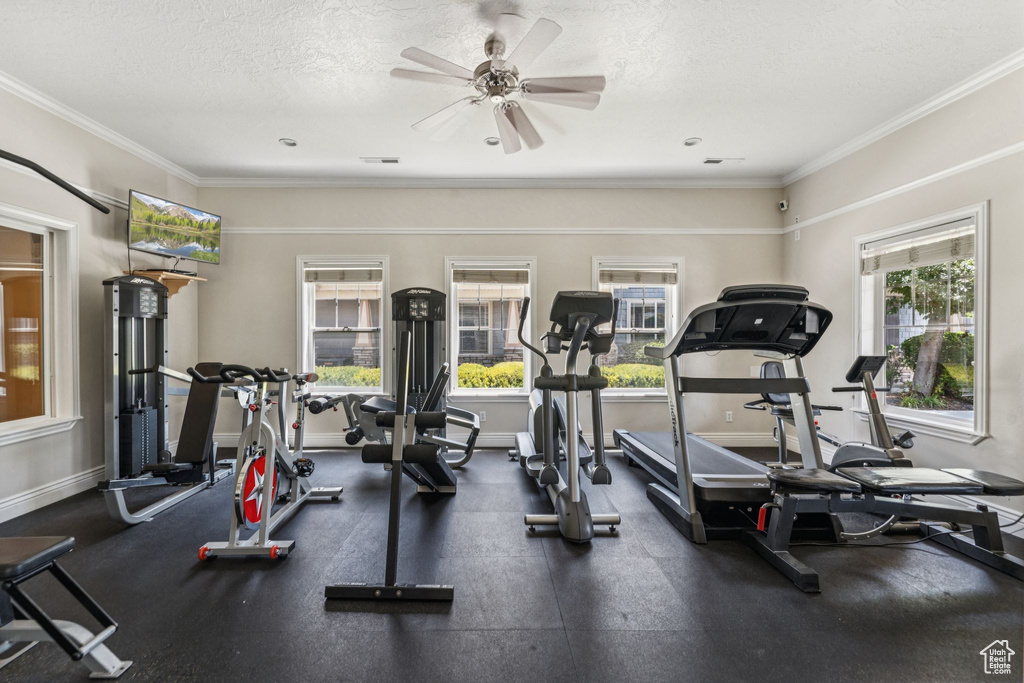 Exercise room with a textured ceiling, a ceiling fan, and ornamental molding