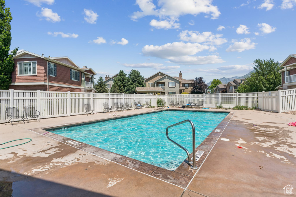 Community pool featuring a patio and a residential view