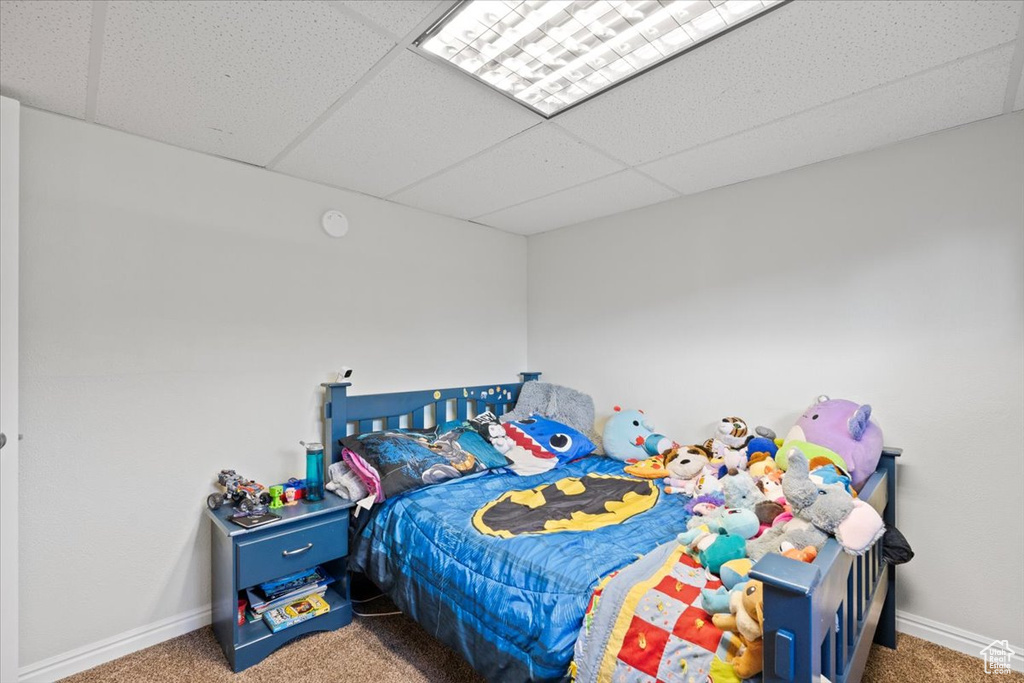 Carpeted bedroom featuring a drop ceiling