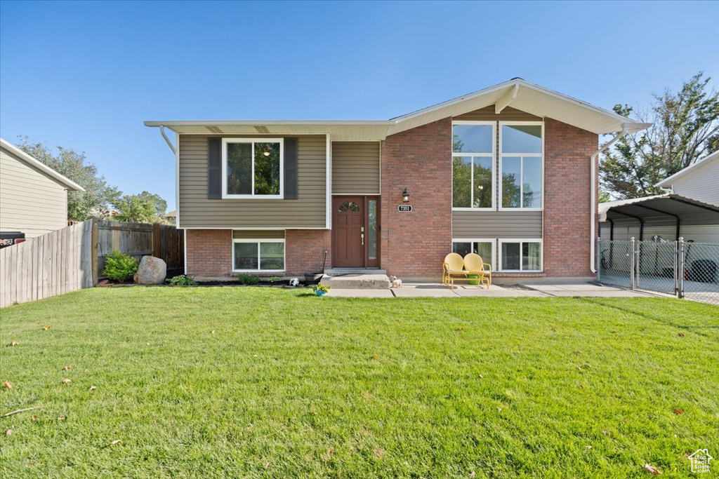 View of front facade featuring brick siding and a detached carport