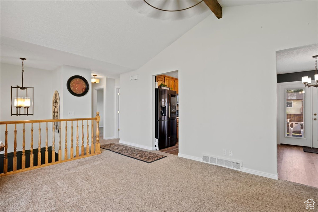 Unfurnished room with a chandelier and carpet floors