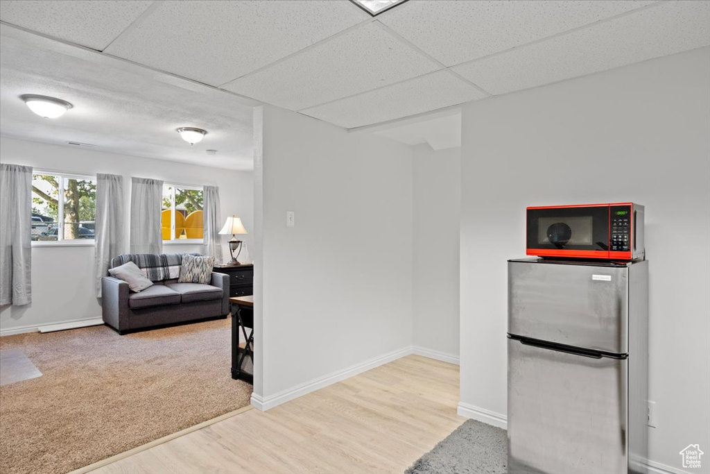 Kitchen featuring freestanding refrigerator, wood finished floors, and a drop ceiling