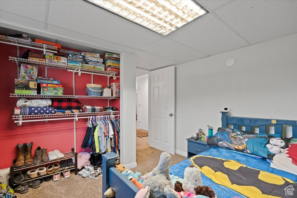 Carpeted bedroom with a closet and baseboards