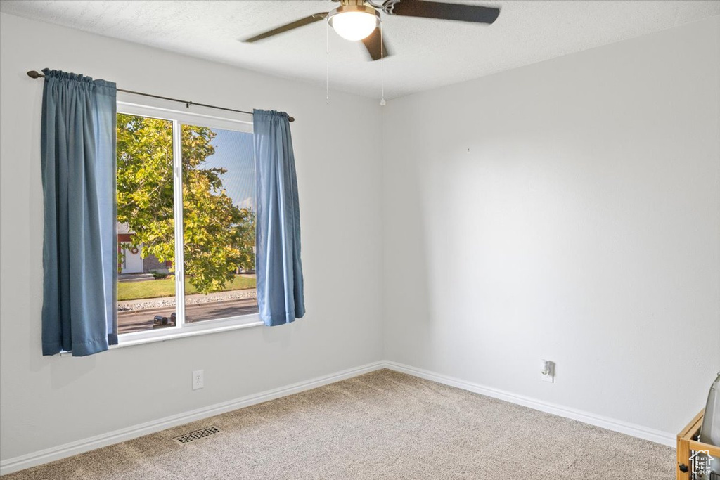 Unfurnished room featuring ceiling fan and carpet floors
